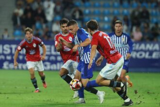 Javi Rueda y Damián, jugadores del Celta Fortuna, peleando por un balón que conduce el jugador rival